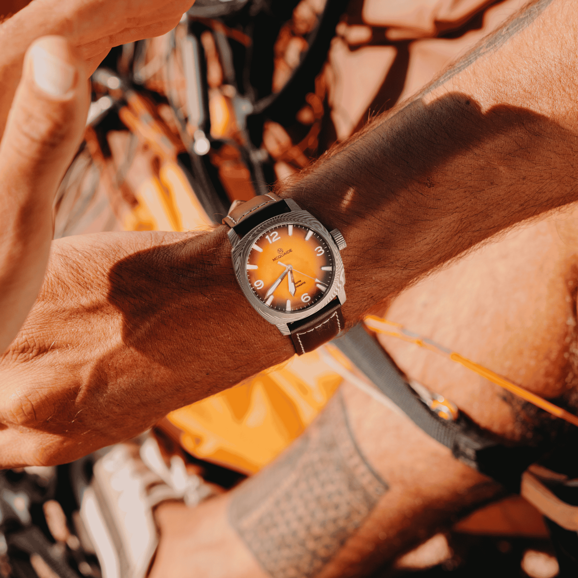 A close-up lifestyle shot of the McQuaide C1 Sunburst worn on a person's wrist.