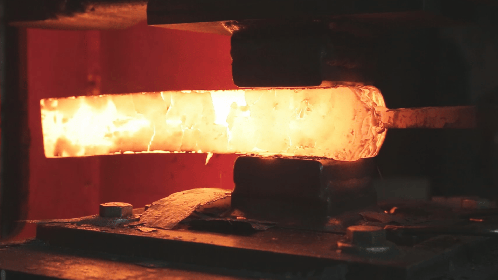 A molten Damascus Steel billet on the press