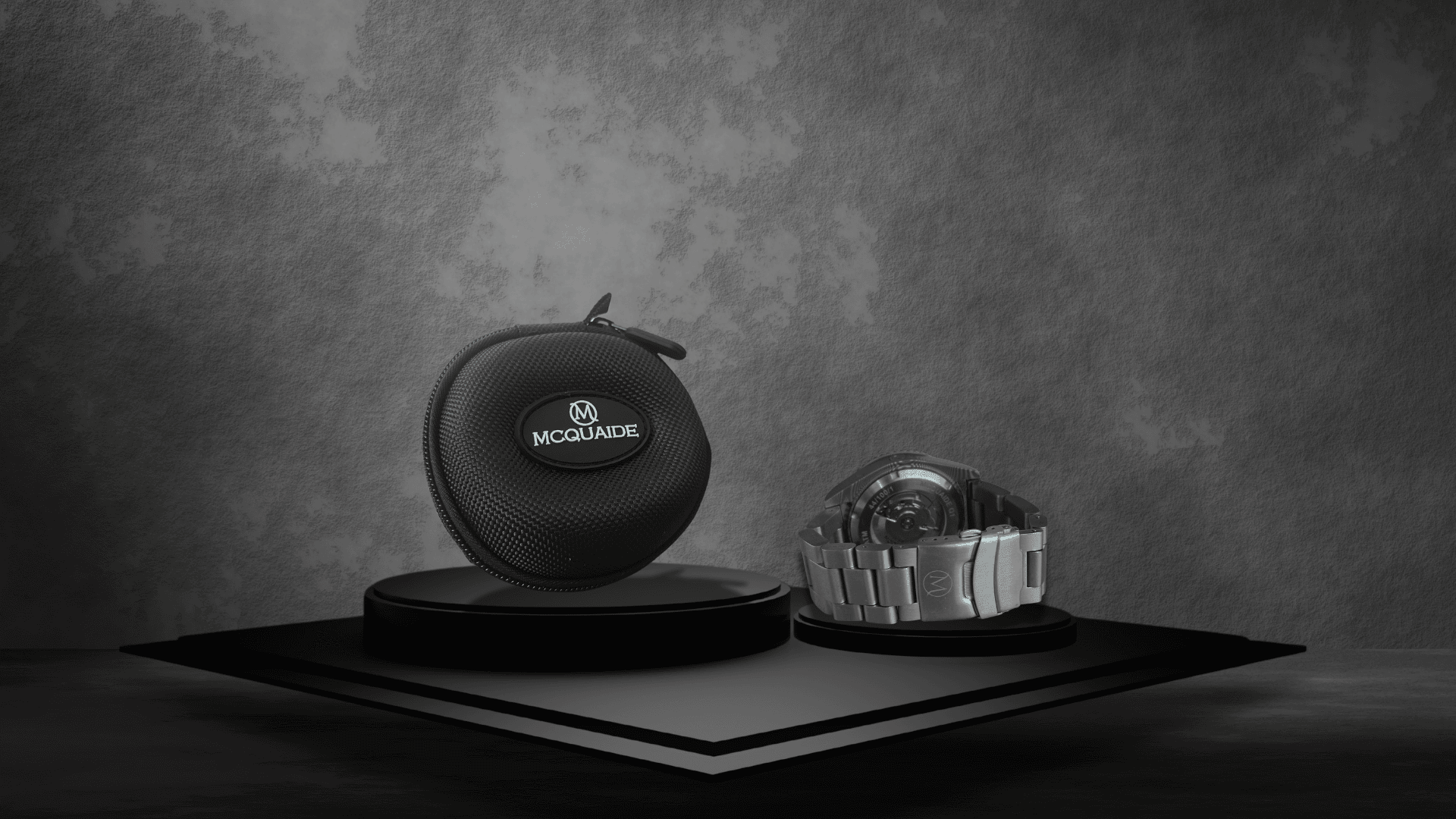 McQuaide travel case with a brushed steel watch bracelet on podiums