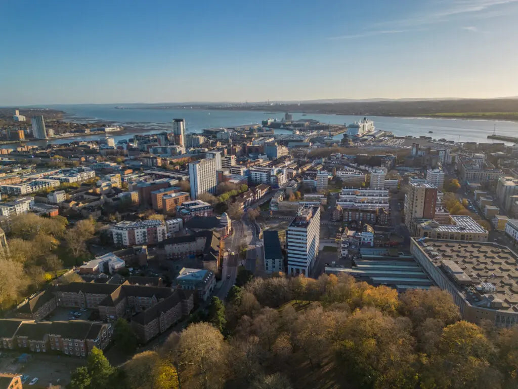 Aerial view of a cityscape with buildings and waterfront on a clear day.